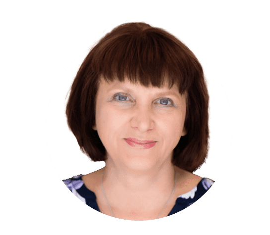 A woman with shoulder-length dark brown hair and bangs is smiling. She is wearing a patterned top. The background of the image is white, and the photo is encircled by a thin white border.