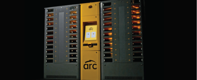 An ARC intelligent locker system. The device has multiple rows of small compartments on either side of the panel, each compartment containing items visible behind a transparent surface.